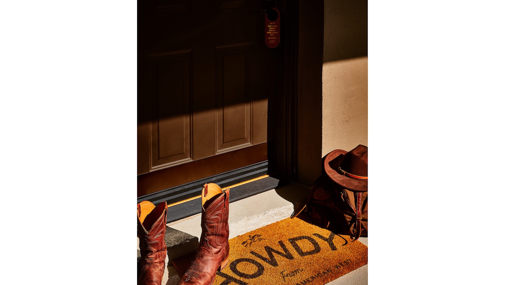 cowboy boots on mat that says howdy