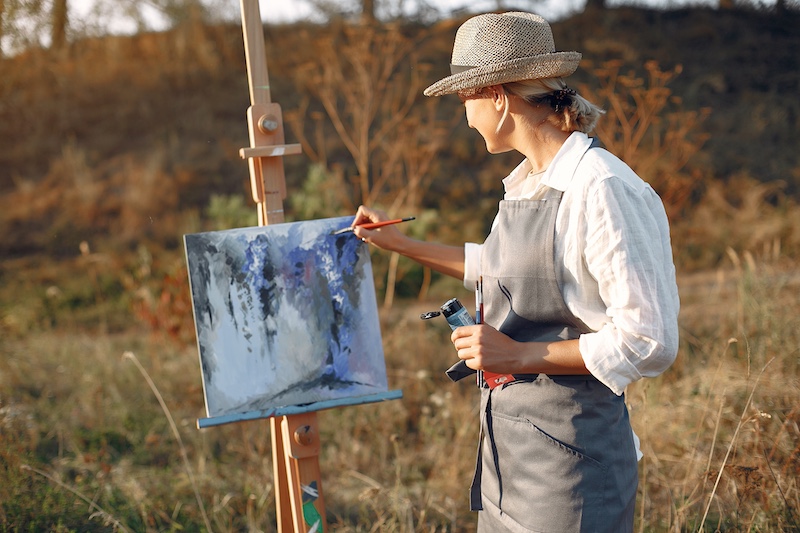 Woman in a apron painting in a field