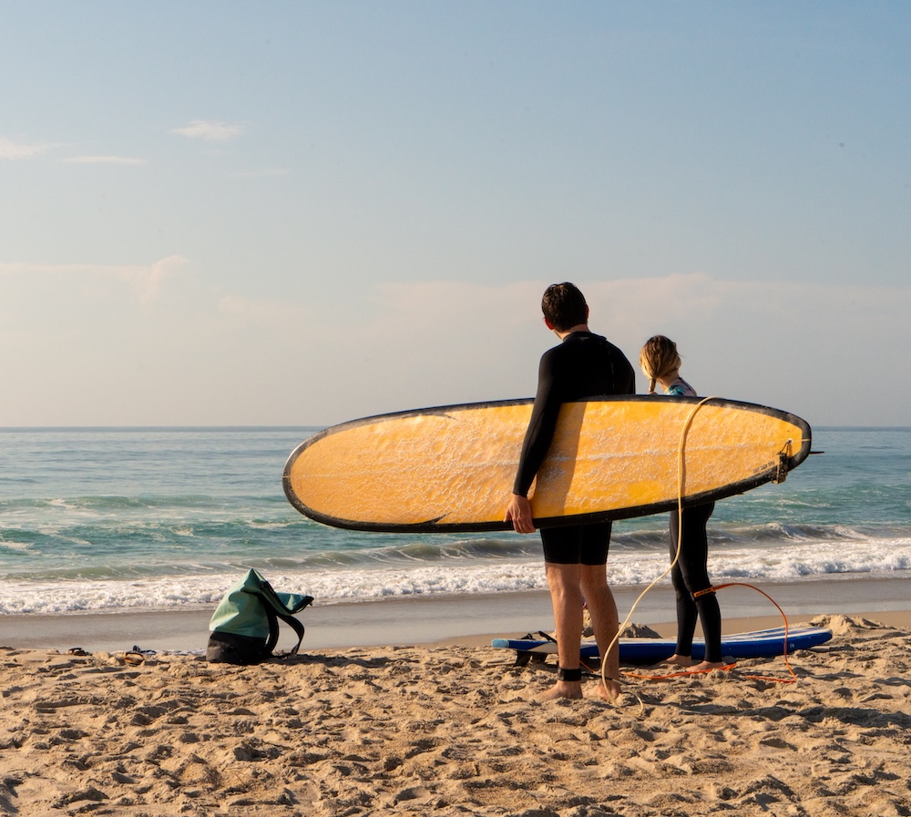 surfers with surfboards on the beach